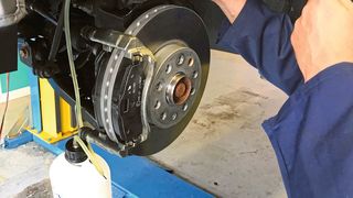 Wenn der Mechaniker die Bremsbeläge auswechselt, sollte er die oft stark verschmutzte Bremsflüssigkeit aus dem Bremssattel nicht in das Hydrauliksystem zurückdrücken.  (Bild: Holz / »kfz-betrieb«)