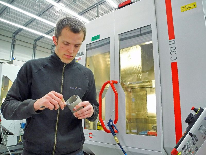 Laserschmelzexperte Stefan Auernhammer bereitet das Laserschmelzteil Kühlmantel für das Fräsen vor. (Bild: Toolcraft)