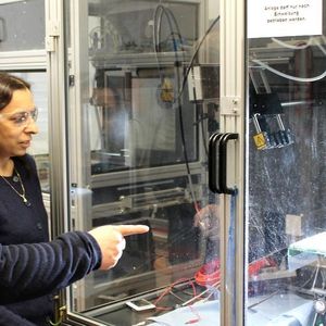 Prof. Dr. Andreas Greiner und Prof. Dr. Seema Agarwal (v.l.) an einer Anlage zum Elektrospinnen. Im Gegenlicht sind die dünnen Fasern zu erkennen, aus denen die Vliesstoffe gebildet werden.