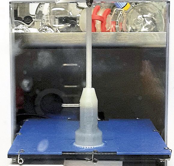 The photos show real reaction approaches (dark solution in the lower area already filled) which are in the inert gas box (Glovebox) to half and almost completely finished printed. (Eike Hübner, TU Clausthal)