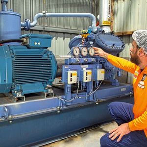 Mark Hyland inspiziert einen Kältekompressor,  der von einem Paket  aus SynRM-Motor und  Frequenzumrichter  angetrieben wird.(Bild:  ABB)