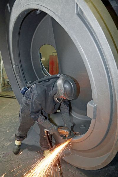 Mit Turboschleifern von Atlas Copco säubert ein Enercon-Mitarbeiter ein großes Gussteil. (Bild: Altas Copco Tools)