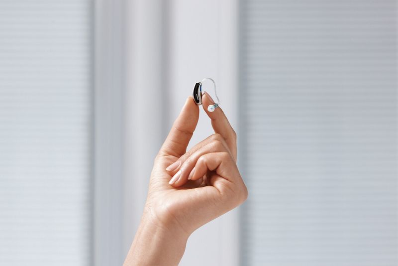Erfolg für die Healthcare-Sparte – Siemens stellt sein neues RIC(Receiver in Canal)-Hörgerät Ace vor. Dank kleiner Bauteile konnte das Gehäuse so zierlich konstruiert werden, dass es diskret hinter dem Ohr verschwindet. (Bild: Siemens)