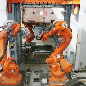 Bild 2: An den Pressen sorgen jeweils zwei Roboter IRB 6600 für das schnelle und genaue Handling der SMC-Teile, während ein dritter nach jedem Pressvorgang die Formwerkzeuge reinigt.