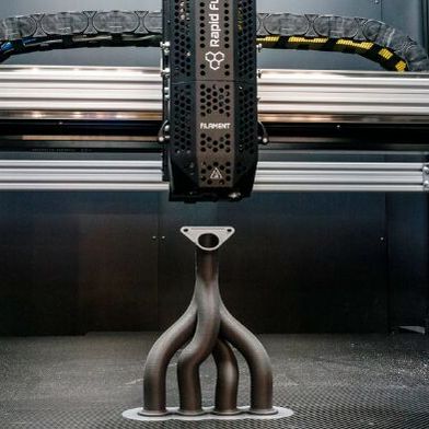 Ein 3D-Drucker bei der Arbeit an einer Art Abgaskrümmer respektive Medienverteilersystem. Das ist wieder so ein komplexes Teil, das in der Rüstung seinen Einsatz findet, weshalb die Mesago Messe Frankfurt der Formnext erstmals einen Defence-Bereich gibt. (Bild: Mesago)