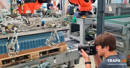 Das Bild zeigt eine Momentaufnahme des „Making of“ für den Fachpack-Film von Trapo mit Multifunktionsgreifer.(Bild:  Trapo)