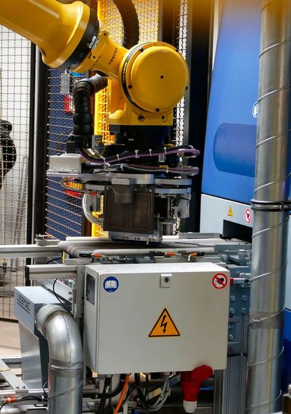 Hier werden die lasergeschnittenen Klingenteile auf das Einlaufband der Entgratmaschine SBM XS 300 G1E1 abgelegt und dem Entgratungsprozess zugeführt.  (Kuhn)