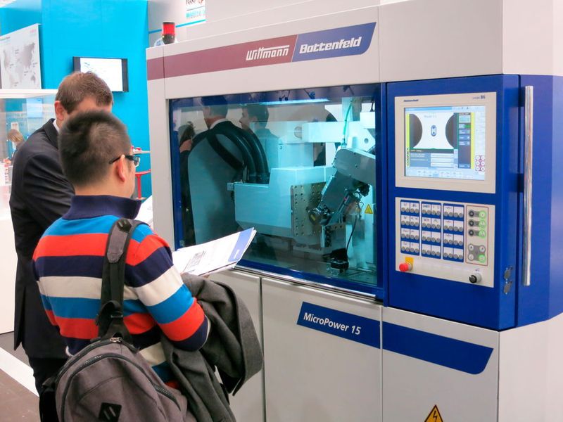 Produktmanager Martin Philipp-Pichler erklärt einem Messebesucher die Vorteile der Spritzgießmaschine Micro Power 15. Ausgestattet als vollwertige Produktionszelle inklusive aufgesetzter Reinraumzelle und kamerabasierter 100-Prozent-Kontrolle. (Bild: Reinhardt)