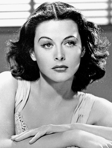 1942 – Das Frequenzsprung-Verfahren: Die Schauspielerin und Erfinderin Hedy Lamarr sah nicht nur besonders gut aus, sondern gilt auch als Miterfinderin des so genannten Frequenzsprung-Verfahrens, das heute im Mobilfunk (GSM) eingesetzt wird. In mehrmonatiger Arbeit tüftelte Lamarr zusammen mit dem Komponisten George Antheil an der Funkfernsteuerung, für die die beiden 1942 schließlich ein Patent erhielten. Die Besonderheit dieser Fernsteuerung waren ständig wechselnde Funkfrequenzen (auch als “Frequency Hopping” oder Frequenzsprung-Verfahren bezeichnet), die zwischen Funkstation und Torpedo mittels identischer Lochstreifen auf ähnliche Weise wie die Klaviere und der Film synchronisiert wurden. Durch den ständigen Frequenzwechsel war die Funkstation schwer anzupeilen und das Signal wenig störungsanfällig. Das Patent wurde vom US-Militär zwar nicht umgesetzt, dennoch setzte sich Frequency Hopping durch. Auch zur Verschlüsselung kann man diese Methode nutzen.  (Bild: gemeinfrei)
