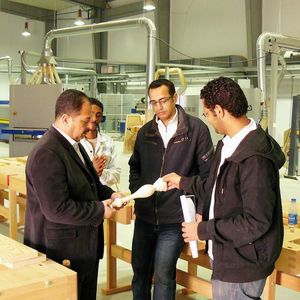 Studenten mit Lehrkraft in der Halle, die die österreichische Felder KG mit Holzbearbeitungsmaschinen ausgestattet hat. Wer an der GUC seinen Abschluss macht, auf den warten national und international sehr gute Karrierechancen.