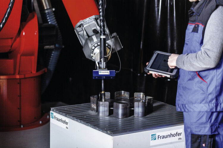 Ein Werker programmiert einen Schweißroboter per Tablet um. (Bild: Fraunhofer-IPA)