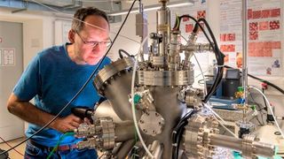 Prof. Dr. Markus Lackinger bei der Arbeit mit einer Ultrahochvakuumkammer an der TU München. Er ist neuen 2D-Materialien mithilfe von Selbstorganisation und Photopolymerisation auf der Spur. (A. Heddergott / TU München)