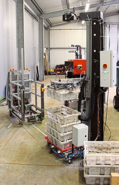 Das fahrerlose Transportsystem steht an der vollautomatisierten Fütterungsstation, um die Container von einem Roboter entgegenzunehmen. (Igus)
