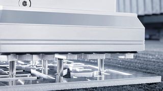 Sicheres Entnehmen: Die freigeschnittenen Teile werden von den frei positionierbaren Pins des «SmartLift» aus dem Restgitter gehoben, von oben drückt der «SortMaster Speed» mit seinen Saugerplatten dagegen. (Bild: Trumpf)