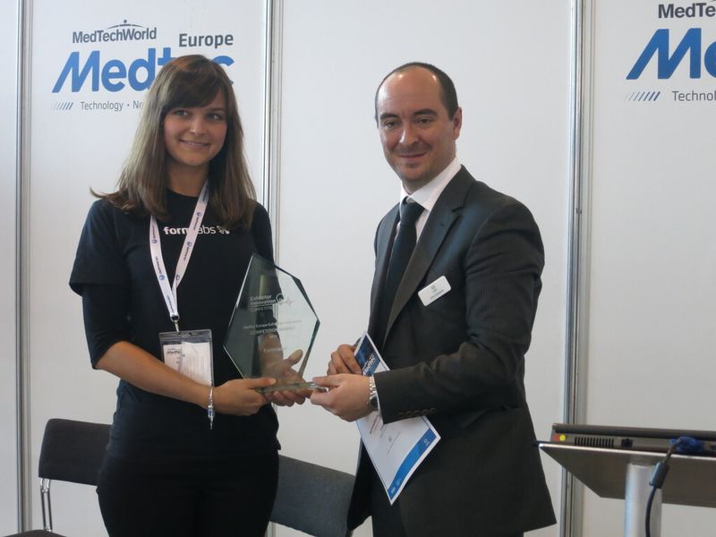 Chris Edwards, Event Director der Medtec Europe, übergibt die Trophäe des 1. Innovationswettbewerbs an Sara Bonomi von der Firma Formlabs. (Reinhardt)