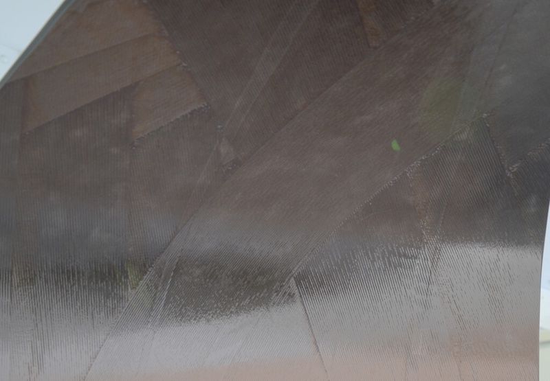 Für die zylindrische Wandung des Boostergehäuses werden Bänder aus CFK-Fasern um einen Kern gewickelt und unter Vakuum mit flüssigem Harz durchsetzt sowie in einem Ofen ausgehärtet. Die Bänderstruktur bleibt sichtbar. (Bild: Michel)