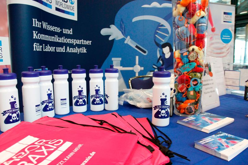 Alles vorbereitet: Taschen, Trinkflaschen und die Plüsch-Riesenmikroben liegen bereit.    Mehr Infos zu den kommenden LAB-SUPPLY-Messen finden Sie auf www.lab-supply.info.  (LABORPRAXIS, C. Lüttmann)