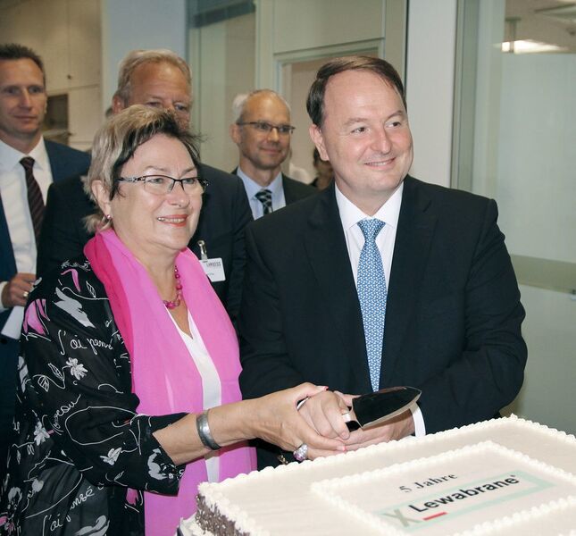 Petra Wust, Oberbürgermeisterin der Stadt Bitterfeld-Wolfen, schneidet mit Jean-Marc Vesselle, Leiter des Geschäftsbereichs LPT, die Geburtstags­torte an und gratuliert. (Ernhofer / PROCESS)