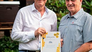 Heinrich Goller, Imker, und Dr. Bernd Pahnke, Sprecher der Geschäftsführung bei Transfracht (v. l.), bei der Übergabe der Partnerschaftsurkunde für das Bienenvolk. (Astrid Doerenbruch)