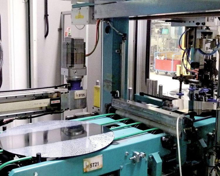Die Edelstahlronden werden mit Vakuumsauggreifern auf einen Feeder gelegt, der die Ronden einer Beölungsstation und anschließ-end der Umformpresse zuführt. Bild: Kuhn (Archiv: Vogel Business Media)