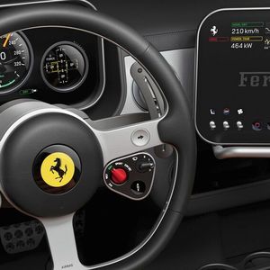 Rund um das retro-inspirierte Dreispeichenlenkrad gruppieren sich Drehregler, Tasten, Wippen und Kippschalter.(Bild:  Ferrari)