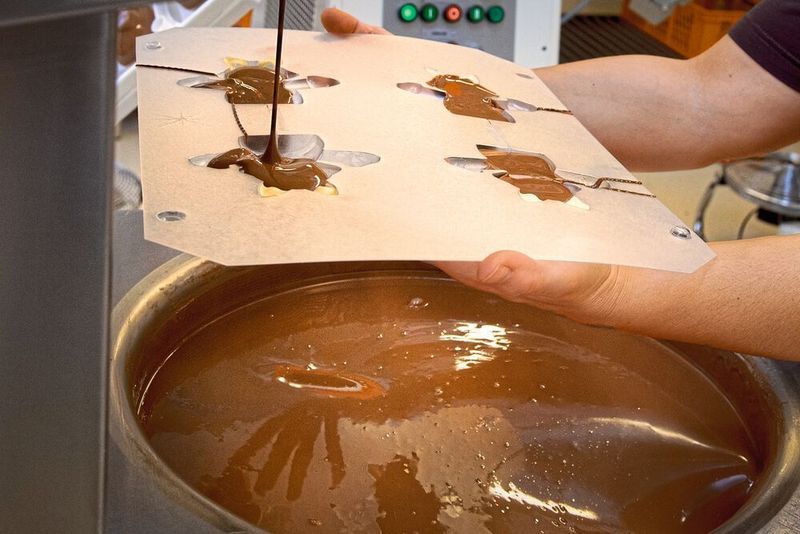 Nach dem Schminken mit weisser Schokolade wird die normale, braune Milch-Schoggi in die Formen eingefüllt. (Thomas Entzeroth)