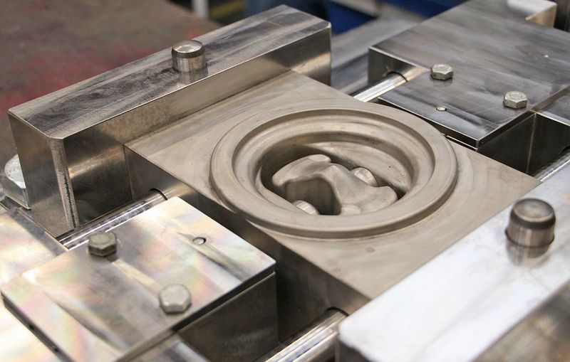 Das Werkzeug verfügt über seitliche Stempel. Wenn sich das Gesenk schliesst, fahren sie aus und erzeugen die Vorbohrung für den Kolbenbolzen.  (IPH)