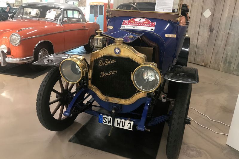 Bei Real Auto in Schweinfurt, einem Oldtimer-Händler und Sponsoren der Rallye, stößt man immer wieder auf Autos, die in den Jahren zuvor an der Sachs Franken Classic teilgenommen hatten. Derzeit gibt es diesen De Dion Bouton DW 2, der vor drei Jahren mitgefahren war.  (Grimm/»kfz-betrieb«)