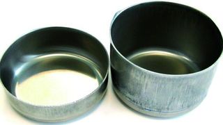 Bild 1: Der Näpfchenziehversuch zeigt, dass hochfeste Blechwerkstoffe aus Aluminium bei einer Temperatur um 200 °C eine deutlich bessere Umformbarkeit aufweisen (rechts) als bei Raumtemperatur (links). (IFU Stuttgart)