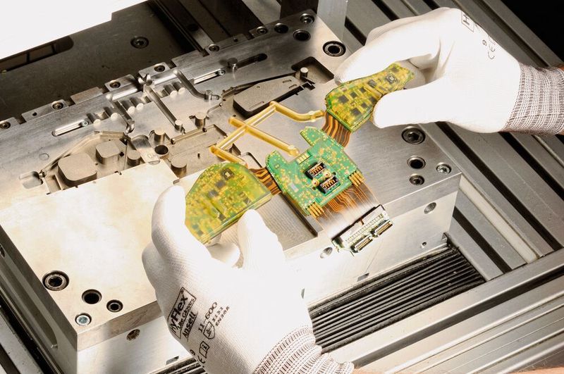 Bild 2:  Hotmelt Moulding am Beispiel eines Feuerwehrhelms. In der Mitte sind Steckverbinder zu sehen, die mittels Dam & Fill ausgespart wurden.  (Bild: Werner Wirth)