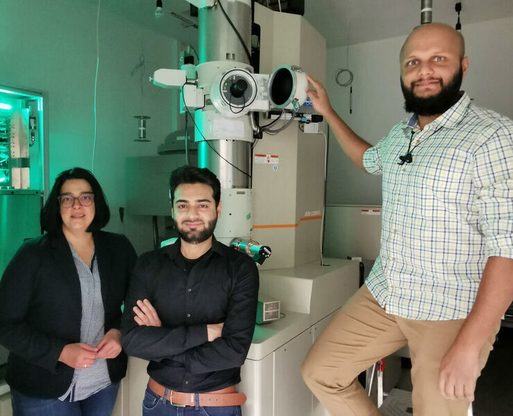 Sie nutzen ausgeklügelte mikroskopische Methoden, um die Grundlage für bessere Batterien zu schaffen (von links): Professorin Dr. Kerstin Volz, Shamail Ahmed und Dr. Anuj Pokle vor dem Raster-Transmissionselektronenmikroskop. (Thomas Demuth)