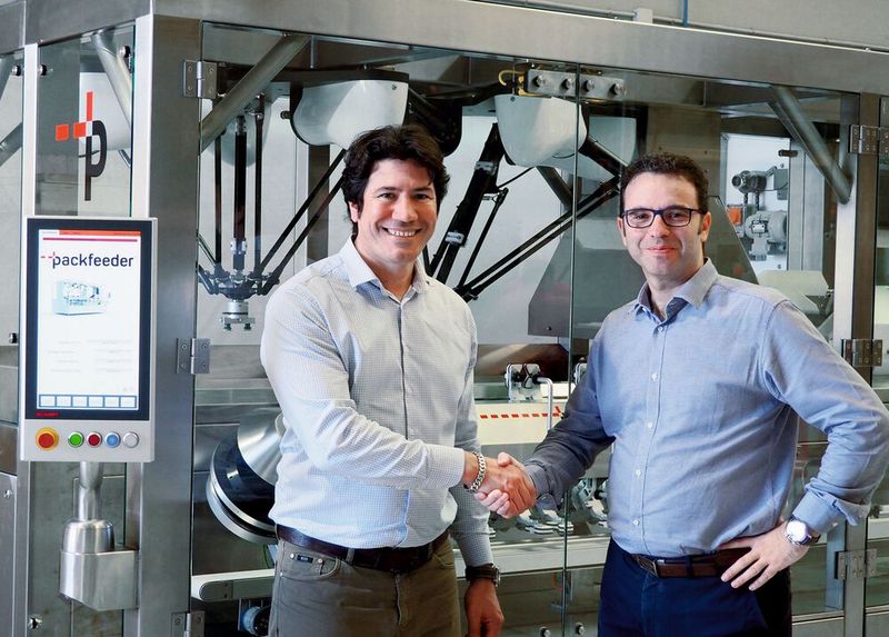 Packfeeder-CEO Ferran Martínez (rechts) und Lluís Moreno (links), Sales Engineer von Beckhoff Spanien, vor dem über ein Multitouch-Control-Panel komfortabel bedienbaren Flaschenaufsteller (Bild: © Packfeeder)