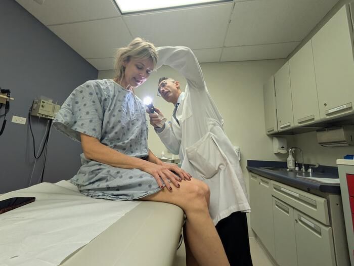 Dr. Pedram Gerami examines the skin of patient and melanoma survivor Heidi Tarr (Source: Ben Schamisso / Northwestern University)