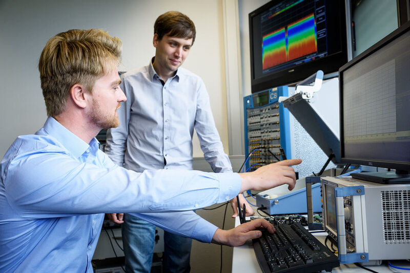 Der Dortmunder Doktorand Stefan Monhof (rechts) und David Rupprecht nutzen ein Software Defined Radio, um verschiedene Mobiltelefone und ihre Chipsätze auf Schwachstellen zu testen. (Roberto Schirdewahn)