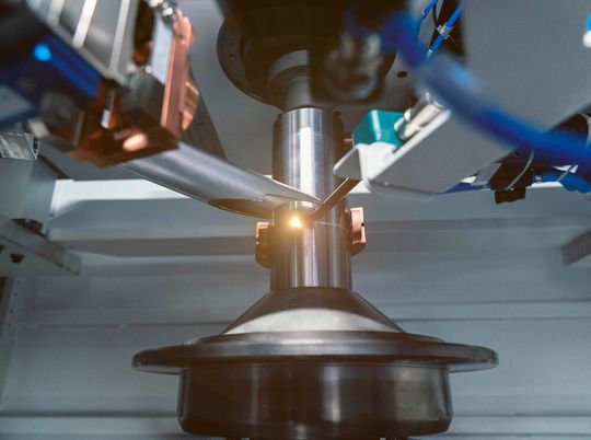 Mit einem produktiven Laserschweißprozess von Emag Lasertec können Fügearbeiten an gebauten Rotorwellen von Elektromotoren erfolgen. Die Maschine heißt ELC6 und wird auf der EMO Hannover gezeigt. Dabei rotiert das Werkstück um das Schweißsystem herum.(Bild:  Emag Lasertec)