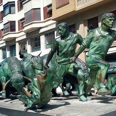 Stierhatz oder das Lasso und die Leine in der Hand? Das abgebildete Monumento al Encierro von Rafael Huerta steht im Pamplona.  (Bild: frei lizenziert: Soli Darnos )