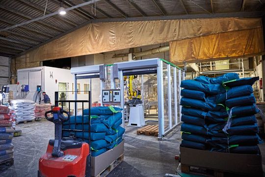 Volle Paletten werden mithilfe einer Ameise aus der Roboterzelle entnommen.(Bild:  Coboworx)