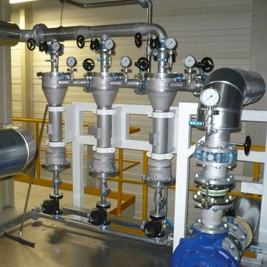 In der Praxis können mehrere Zentrifugalabscheider parallel angeordnet werden. Das Bild zeigt eine sogenannte Batterie, bestehend aus drei Zentrifugalabscheidern. Die Summe der Einzeldurchsatzleistung jedes Zyklons ergibt die Gesamtdurchsatzleistung der Batterie.(Bild:  Wolftechnik)