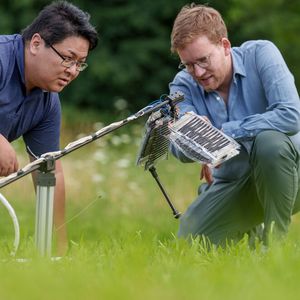 Buchner (rechts) erklärt: „Sobald wir Spannung an die Elektroden anlegen, ziehen sie sich aufgrund statischer Elektrizität gegenseitig an. Wenn ich einen Luftballon an meinem Kopf reibe, bleiben meine Haare aufgrund der gleichen statischen Elektrizität am Ballon haften.“(Bild:  MPI für Intelligente Systeme/Wolfram Scheible)