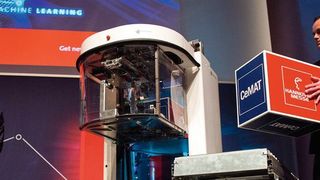 Auf der Cemat-Preview hält Deutsche-Messe-Chef Dr. Jochen Köckler einen Demowürfel, der zuvor von Soto übergeben wurde. (Magazino)