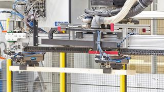 Die Anlage sägt, verlegt und nagelt vollautomatisch dreidimensional gewölbte Dachträger aus unterschiedlich breiten und 50 mm dicken Kanthölzern. (Schunk)