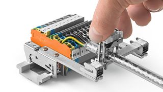 Durch das Drücken der zwei seitlichen Betätigungselemente wird die Feder gelöst, sodass der Schirmklemmbügel fest auf der Schiene sitzt. (Wago)