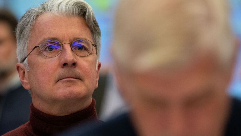 Rupert Stadler (links), ehemaliger Vorstandsvorsitzender der Audi AG, und der Mitangeklagte Wolfgang Hatz (rechts, unscharf), ehemaliger Audi-Ingenieur, Forschungs- und Entwicklungsvorstand bei Porsche sowie Leiter der Aggregateentwicklung bei Volkswagen, sitzen im Sitzungssaal des Landgericht München auf ihren Plätzen. (Bild:  picture alliance/dpa | Sven Hoppe)