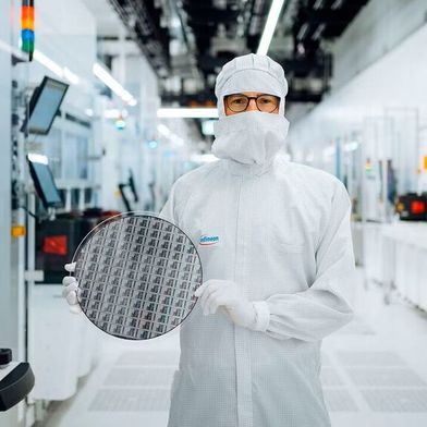 A technician in the clean room at Infineon Technologies in Villach, Austria, holds a 300 mm gallium nitride wafer. (Image:Infineon Technologies)