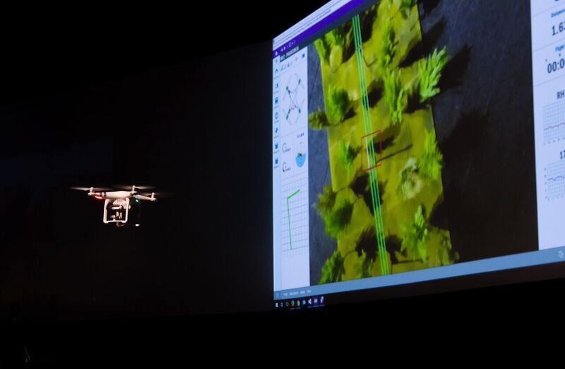 Diese kleine Drohne schwebt über einem Landschaftsmodell und projiziert das dabei aufgenommene Videobild auf die Leinwand. (© IFS)