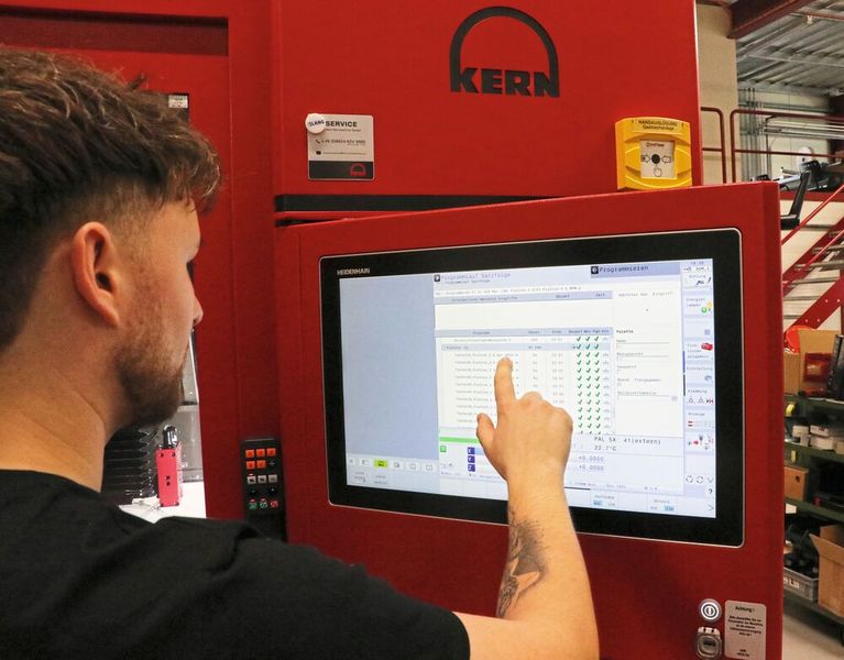 Polymechaniker Kevin Riccius schreibt seine Bauteilprogramme und setzt diese anschließend in den Batch-Prozess-Manager der Heidenhain-Steuerung TNC 640. Damit wird die Laufzeit während des automatisierten Fertigungsprozesses deutlich verkürzt. (Bild: Kern Mikrotechnik GmbH)