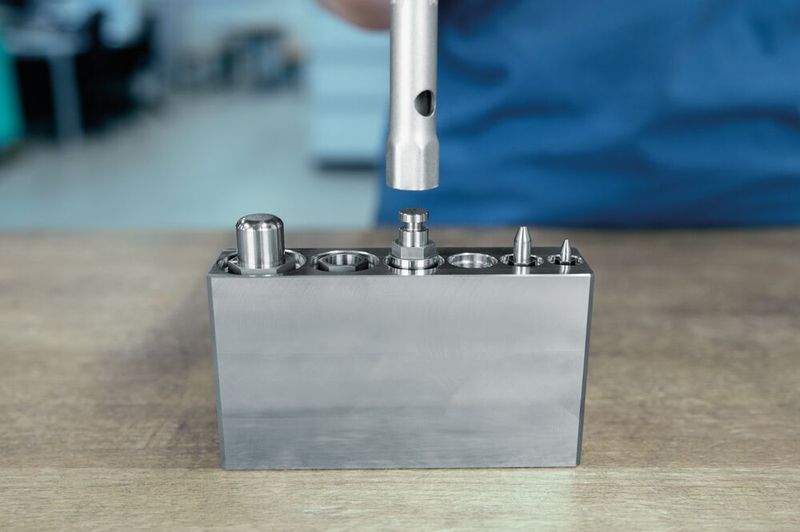 The new guide bush with male thread, with collar E 5708 makes the installation and removal of round active parts with collar possible directly from the working plane.  (Source: Meusburger)