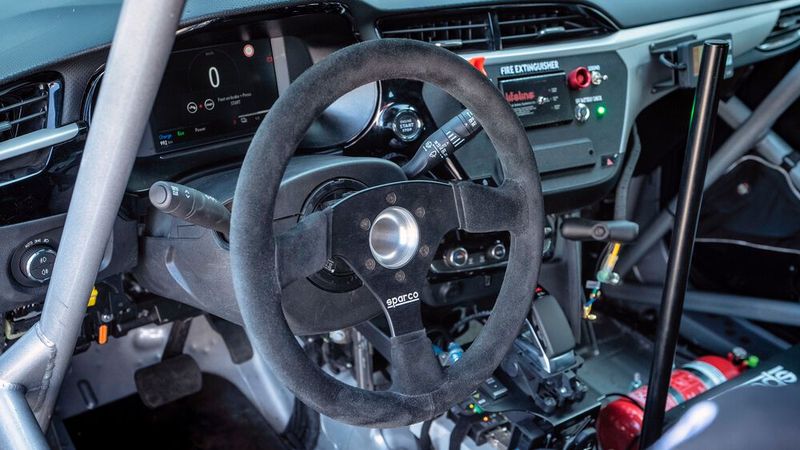 Überrollkäfig, Schalensitze, diverse Leitungen, Kabel, Schalter und Displays: Im engen Cockpit des Opel Corsa sieht es fast so aus wie in jedem anderen Rallyeauto. (Bild: Opel)