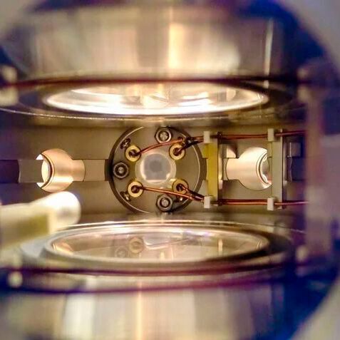 Blick in die Hauptvakuumkamer des NaK-Molekülexperiments. In der Mitte werden vier Hochspannungskupferdrähte zu einer Ultrahochvakuum-Glasküvette geführt, in der die ultrakalten polaren Moleküle erzeugt wurden.