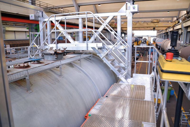 Über den dachseitigen Überstieg kann das Wartungsteam schnell und sicher von einer Seite auf die andere wechseln. Dank der flexiblen Ausschübe lassen sich die Arbeitsplattformen exakt an die unterschiedlichen Kesselwagenprofile andocken und die Arbeitsfläche um 50 % erweitern. (Bild: Günzburger Steigtechnik)